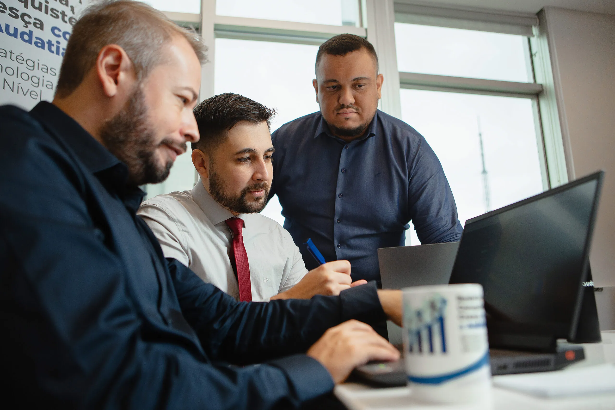 Consultores da Audatia trabalhando junto a um cliente na configuração da plataforma de gestão